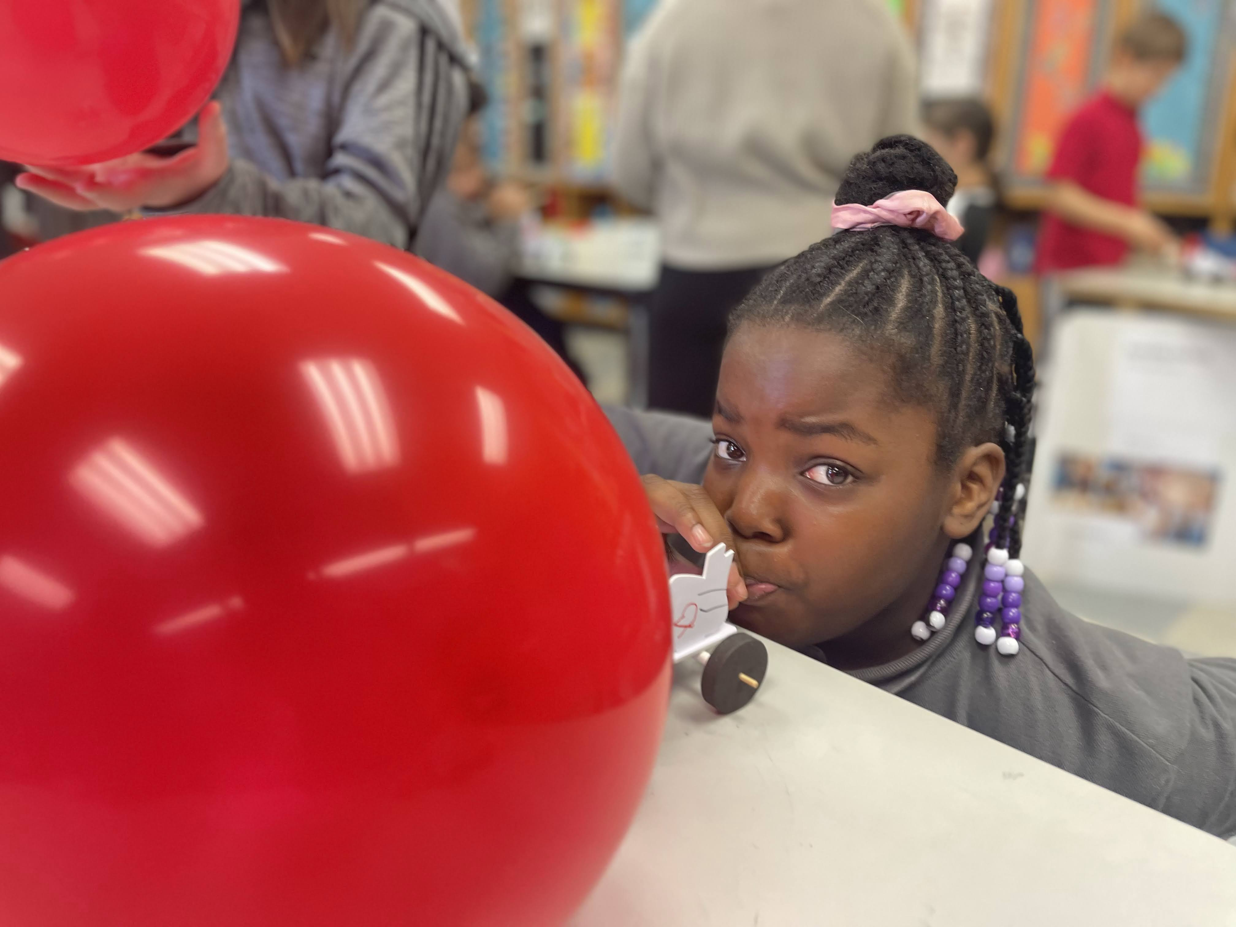 Student Blows up Balloon for a STEM Air Powered Car Project